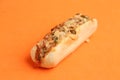 Closeup shot of a bread loaf with pizza toppings on an orange background