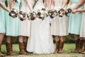 Closeup shot of the bride and the bridesmaids holding flowers with a blurred background