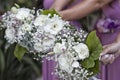 Closeup shot of bridesmaids bouquets: white roses with small flowers and leaves