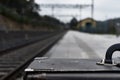 Closeup shot of a briefcase next to the tracks of the railway station Royalty Free Stock Photo