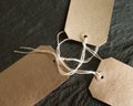 Closeup shot of a brown kraft tags on a black surface Royalty Free Stock Photo
