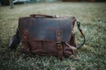 Closeup shot of a brown leather satchel on the green grass