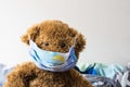 Closeup shot of a brown teddy bear wearing facemask Royalty Free Stock Photo