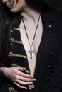 Closeup shot of a brunette woman with a christian symbolic necklace on her neck.