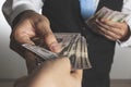 Closeup shot of a businessman giving money to another hand, doing exchanging