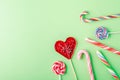 Closeup shot of candy canes and lollipops on a green background - perfcet for a cool wallpaper