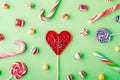 Closeup shot of candy canes and other candies on a green background - perfcet for a cool wallpaper