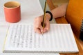 Closeup shot of a caucasian girl writing sheet music while holding a classical guitar Royalty Free Stock Photo