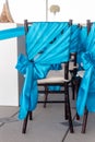 Closeup shot of the chairs decorated with turquoise bows in the wedding hall Royalty Free Stock Photo