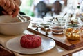 Closeup shot of chef making steak tartare on trolley with spices and ingredients