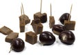 Closeup shot of chestnut cakes on toothpick and chestnuts isolated on a white background Royalty Free Stock Photo