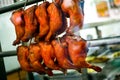 Closeup shot of chicken legs hanging from hooks in the butcher shop