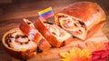 Closeup shot of chocolate bread with Venezuela flag and autumn leaves on a board
