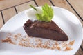 Closeup shot of chocolate dessert with peanut and walnut pieces on a white plate background