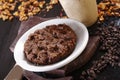 Closeup shot of chocolate oat cookie on a white plate next to chocolate chips Royalty Free Stock Photo