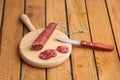 Closeup shot of chopped chorizo sausage on a wooden board and a knife on a wooden table