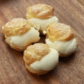 Closeup shot of choux pastry buns on a wooden plate Royalty Free Stock Photo