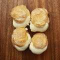 Closeup shot of choux pastry buns on a wooden plate Royalty Free Stock Photo