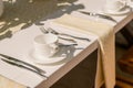 Closeup shot of clean cutlery, tea cups, saucers, and cups set up on a table Royalty Free Stock Photo