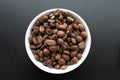Closeup shot of coffee beans in a white bowl on a black background Royalty Free Stock Photo