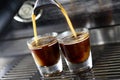 Closeup shot of coffee machine brewing fresh espresso in glass cups