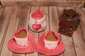 Closeup shot of coffee mugs and a jar next to a wooden lantern full of rose petals on a wooden table Royalty Free Stock Photo