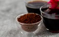 Closeup shot of coffee powder in glass bowl with defocused black coffee