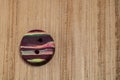 Closeup shot of a colorful button put on a wooden surface Royalty Free Stock Photo