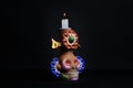 Closeup shot of a colorful clay candlestick skull on a black background