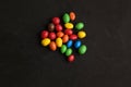 Closeup shot of colorful coated chocolate candies isolated on a black background