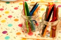 Closeup shot of colorful crayons in glass jars Royalty Free Stock Photo