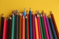 Closeup shot of colorful pencils on a yellow background Royalty Free Stock Photo