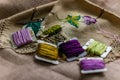 Closeup shot of colorful yarn rolls on a piece of fabric with cross-stitch art of purple grapes Royalty Free Stock Photo