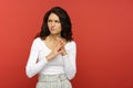 Studio shot of confused pensive girl with hands in front of body think of problem solution look side