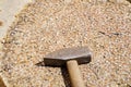 Closeup shot of a construction hammer on a thick trunk covered with nails Royalty Free Stock Photo