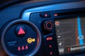 Closeup shot of the control panel on a car's steering with glowing symbols on the buttons