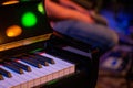 Closeup shot of the corner of a piano with colorful lights around Royalty Free Stock Photo