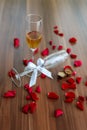Closeup shot of a couple of glasses of champagne and red roses on a wooden table