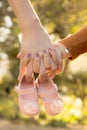 Closeup shot of a couple holding hands with a pair of baby shoes. Concept of family. Royalty Free Stock Photo