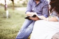 Closeup shot of a couple sitting and reading the bible with a blurred background Royalty Free Stock Photo