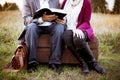 Closeup shot of a couple sitting on a suitcase while reading the bible with a blurred background Royalty Free Stock Photo