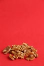 Closeup shot of the cracked walnuts on the red background Royalty Free Stock Photo