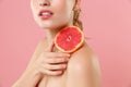 Close up shot cropped blonde half naked woman 20s perfect skin nude make up hold in hand grapefruit isolated on pastel Royalty Free Stock Photo