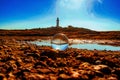 Closeup shot of a crystal ball with a lighthouse on the rocky seashore