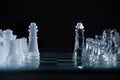 Closeup shot of crystal chess pieces on a glass board on black background Royalty Free Stock Photo