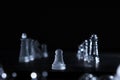 Closeup shot of crystal chess pieces on a glass board on black background Royalty Free Stock Photo