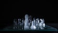 Closeup shot of crystal chess pieces on a glass board on black background Royalty Free Stock Photo