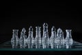 Closeup shot of crystal chess pieces on a glass board on black background Royalty Free Stock Photo