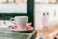 Closeup shot of a cup of coffee on a wooden table at the beach Royalty Free Stock Photo