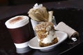 Closeup shot of the cup of latte coffee with a delicious pastry cake Royalty Free Stock Photo